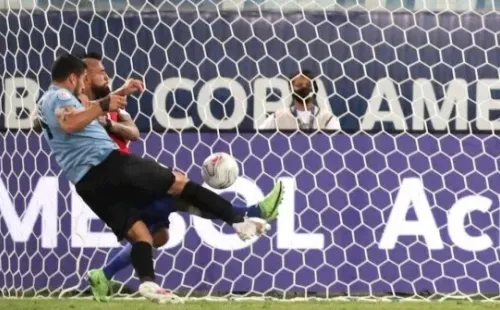 Arturo Vidal intenta puntear el balón ante la arremetida de Luis Suárez (Getty Images)