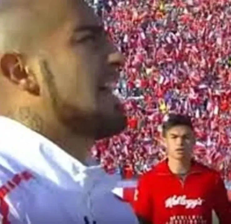 Un juvenil Gabriel Suazo mira con atención a Arturo Vidal mientras entona el himno chileno