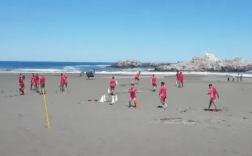 El plantel de Ñublense tuvo una intensa pero distinta jornada de entrenamiento en la playa de Cobquecura, hasta donde llegaron algunos hinchas a alentarlos. (Foto: Captura Canal 9 Bio Bio)