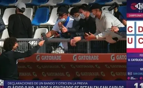 Un hincha de la UC le pasa su teléfono a Falcón para sacarse una foto (TNT Sports)