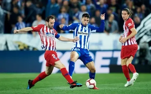 Jonathan Calleri disputa la pelota con el uruguayo Diego Godín en un duelo entre el Alavés y el Atlético Madrid.