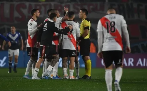 Roberto Tobar rodeado de jugadores de River Plate, ofuscados por la decisión de anular el gol de Matías Suárez.