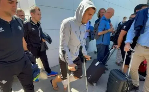 Juanmi llegó en muletas a Sevilla junto a la delegación del Betis, y tendrá que pasar largo tiempo fuera de las canchas. | Foto: El Desmarque Sevilla