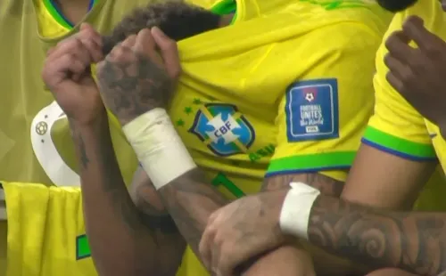 Neymar se tapa la cara de dolor en el banco de Brasil.
