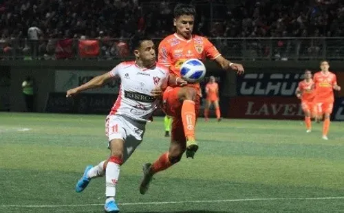 Nicolás Palma, quien fue expulsado en Cobreloa, lucha un balón con Maximiliano Quinteros. (Agencia Uno).