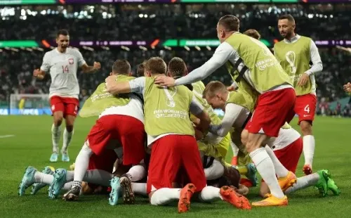 La montaña de jugadores de Polonia en la celebración del primer gol de Robert Lewandowski en un Mundial. (Getty Images 2022).