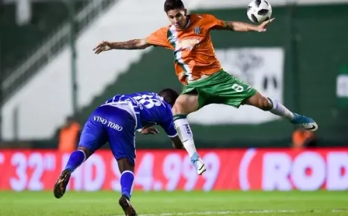 El paraguayo Danilo Ortiz (de naranja/Banfield) disputa un balón con el fallecido Santiago García en un duelo entre el Taladro y Godoy Cruz (Getty Images).
