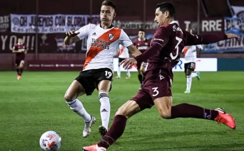 Guillermo Burdisso despeja un balón ante la insistencia de Braian Romero en un partido entre Lanús y River Plate. (Getty Images).