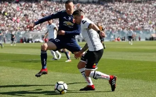 Damián Pérez en acción durante un Superclásico: acá disputa un balón con Rodrigo Echeverría. (Agencia Uno).