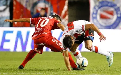 Luciano Cabral traba una pelota a Ariel Rojas en un partido entre Argentinos Juniors y River Plate. (Getty Images).