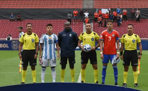 Iván Román en el sorteo de capitanes con Claudio Echeverri, la figura de Argentina.