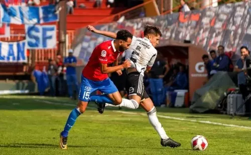 Leonardo Gil disputa un balón con Cristián Cuevas. (Guille Salazar/RedGol).