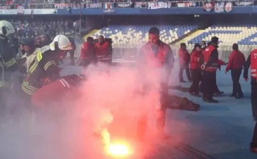 Algunas de las bengalas que cayeron en el Clásico Universitario jugado en el Ester Roa Rebolledo. (Photosport).