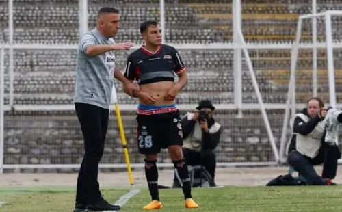 Jaime García le da indicaciones a Manuel Rivera, uno de los polifuncionales jugadores que tiene en Ñublense. (Photosport).