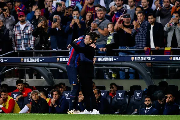 Xavi y Piqué se funden en un abrazo a un costado de la banca del FC Barcelona. | Foto: Getty
