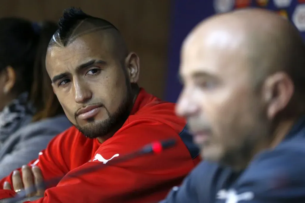 Arturo Vidal mira a Jorge Sampaoli en una conferencia de prensa de la Roja. (Andrés Piña/Photosport
