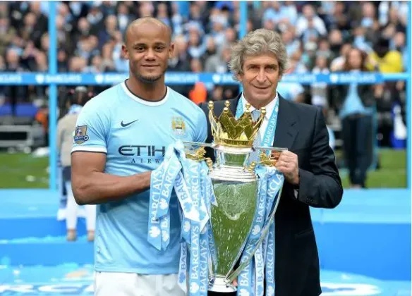 Kompany y Pellegrini con el trofeo de la Premier League que ganaron en el Manchester City. (Getty).