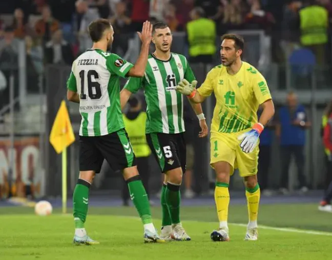 Los campeones del mundo Germán Pezzella y Guido Rodríguez felicitan a Claudio Bravo en el Betis. (Getty Images).