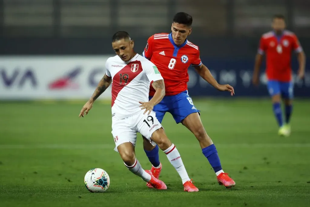 Yoshimar Yotún recibe la marca de Marcelino Núñez. Perú venció a Chile en Lima por las Eliminatorias a Qatar 2022. (Daniel Apuy/Getty Images).