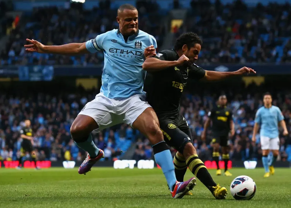 Jean Beausejour por el Wigan en un duelo ante el Manchester City: recibe la marca del belga Vincent Kompany, hoy DT del portero chileno Lawrence Vigouroux en el Burnley de la Premier League. (Alex Livesey/Getty Images).