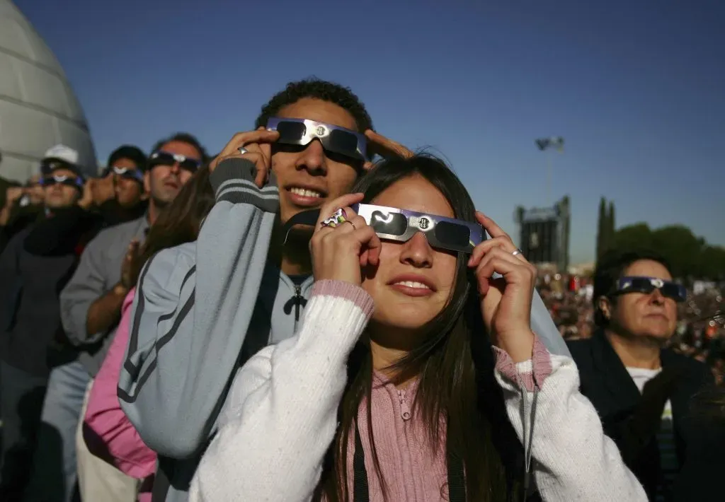 Un grupo de personas utiliza lentes protectores para ver un eclipse anular en el Planetario el 3 de octubre de 2005 en Madrid, España | Foto: Getty Images
