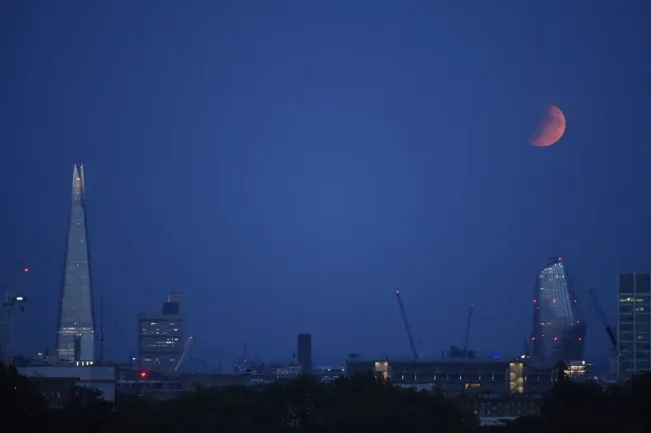 Un eclipse lunar parcial aparece sobre el horizonte el 16 de julio de 2019 en Londres, Inglaterra | Foto: Getty Images