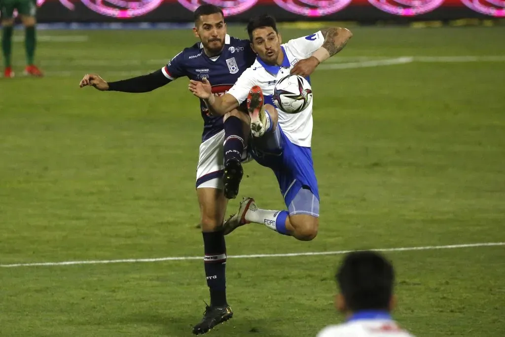 Luis Haquin disputa un balón ante Fernando Zampedri  (Jonnathan Oyarzun/Photosport).