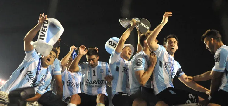 Luciano Aued alza la copa de campeón y Gabriel Hauche tapa su rostro con el colgante azul de la medalla.