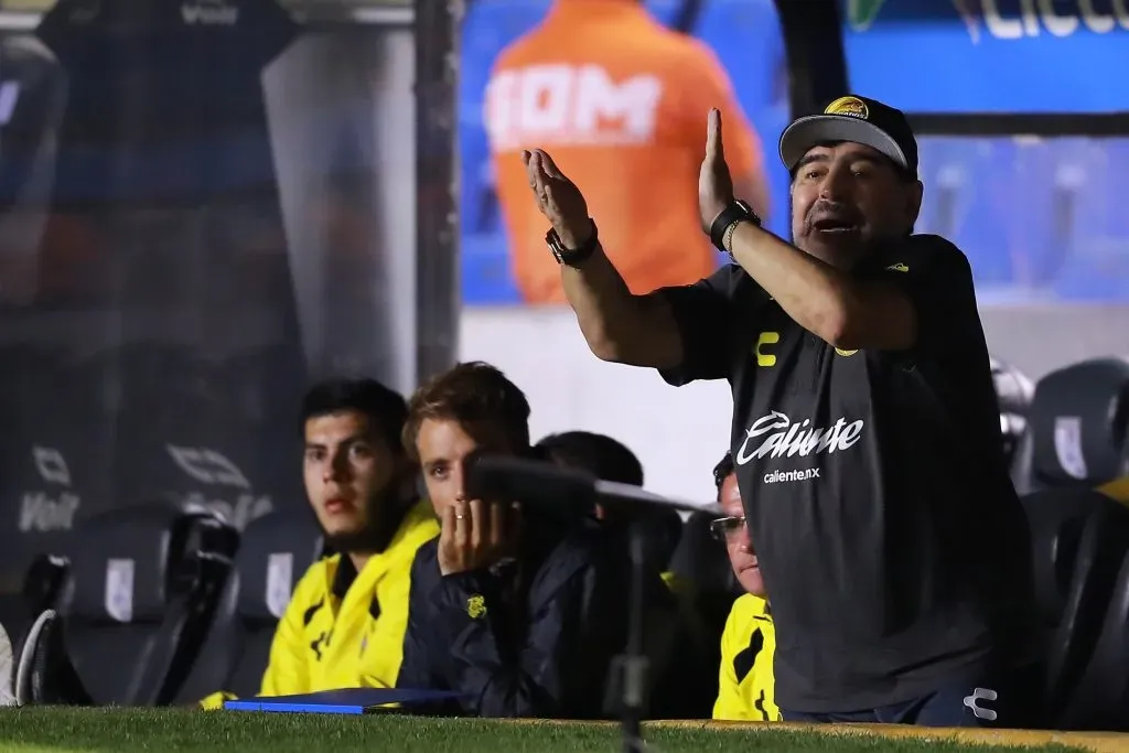 Diego Maradona da indicaciones mientras José Altieri piensa qué hacer con la mano en el rostro. (Hector Vivas/Getty Images).