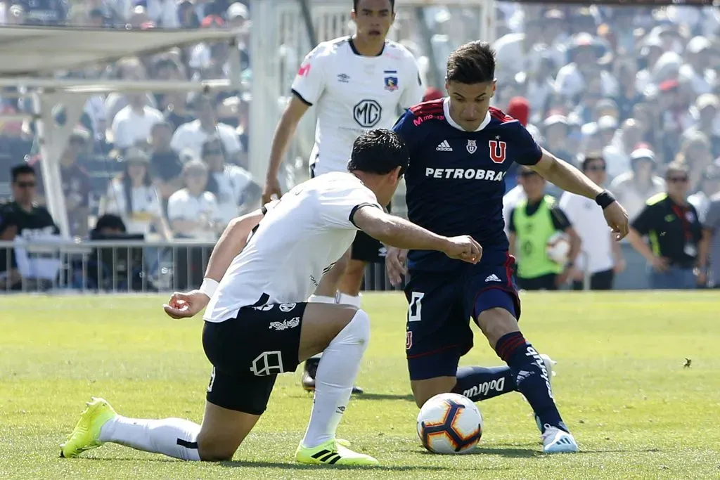 Nicolás Oroz en acción durante un Superclásico ante Colo Colo. Julio Barroso marca al argentino ante la mirada a distancia de Gabriel Suazo. (Ramon Monroy/Photosport).