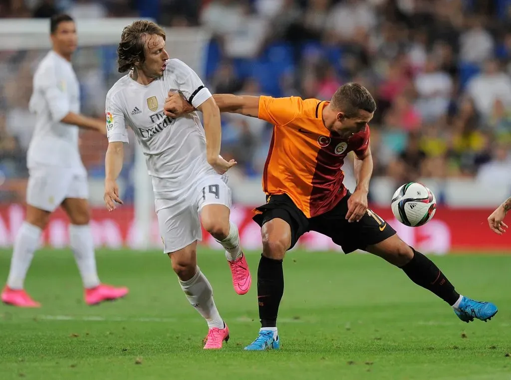 Lukas Podolski lucha con Luka Modriç en un partido entre Galatasaray y Real Madrid por la Champions League. (Denis Doyle/Getty Images).
