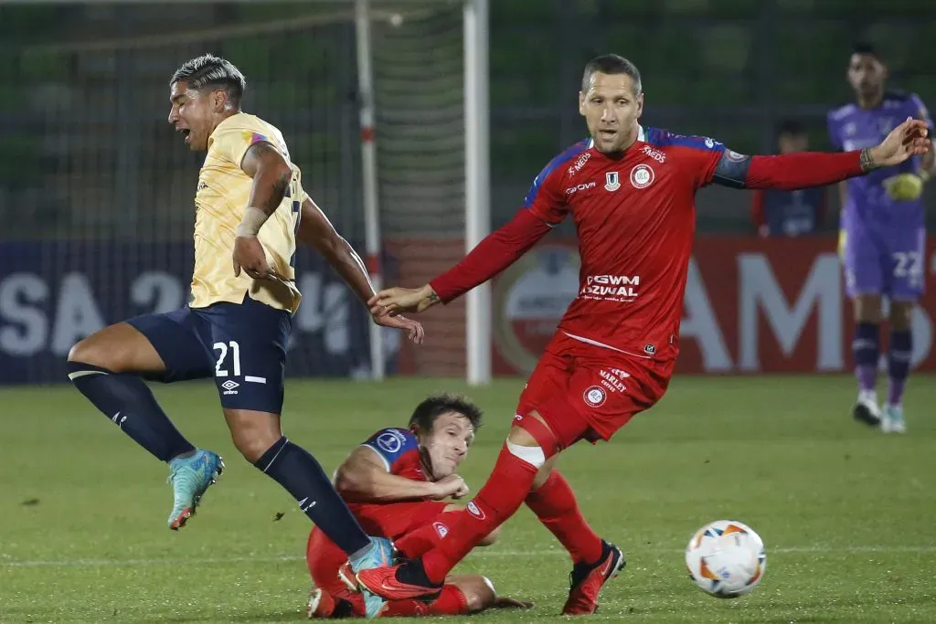 Luciano Aued lucha una pelota con Luciano Nieto. En el piso está Franco Soldano. (Sebastian Cisternas/Photosport).