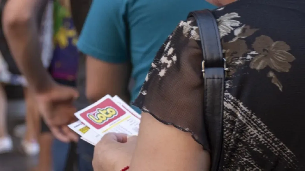 Una mujer sostiende un cartón del Loto