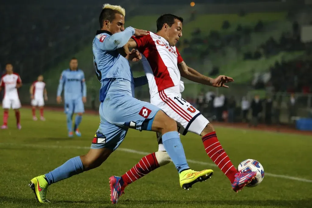Cristian Báez en acción ante Universidad de Chile por Deportes Iquique. Acá lucha un balón con Sebastián Ubilla. (Andrés Piña/Photosport).