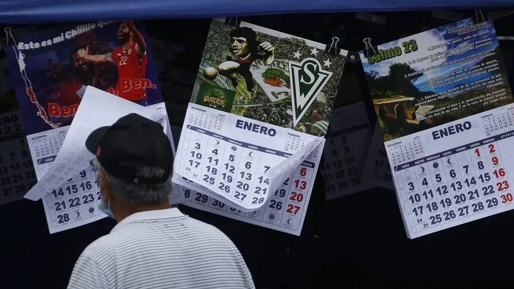 Un hombre fotografiado de espalda mira unos calendarios