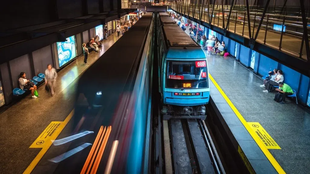 Personas y trenes en una estación del Metro de Santiago.