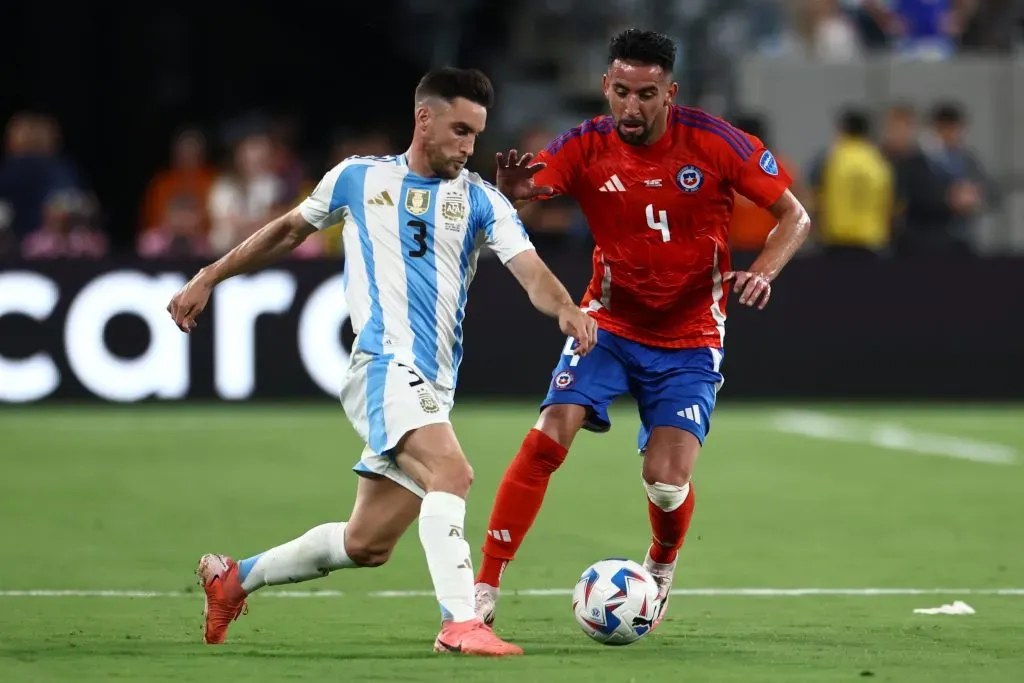 Nicolás Tagliafico mano a mano con Mauricio Isla. No se repetirá en las Elminatorias. (Tim Nwachukwu/Getty Images).