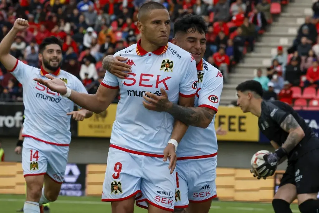 Ariel Uribe festeja con Leandro Benegas el segundo gol de Unión Española. Atrás se suma Ignacio Núñez. (Andres Pina/Photosport).