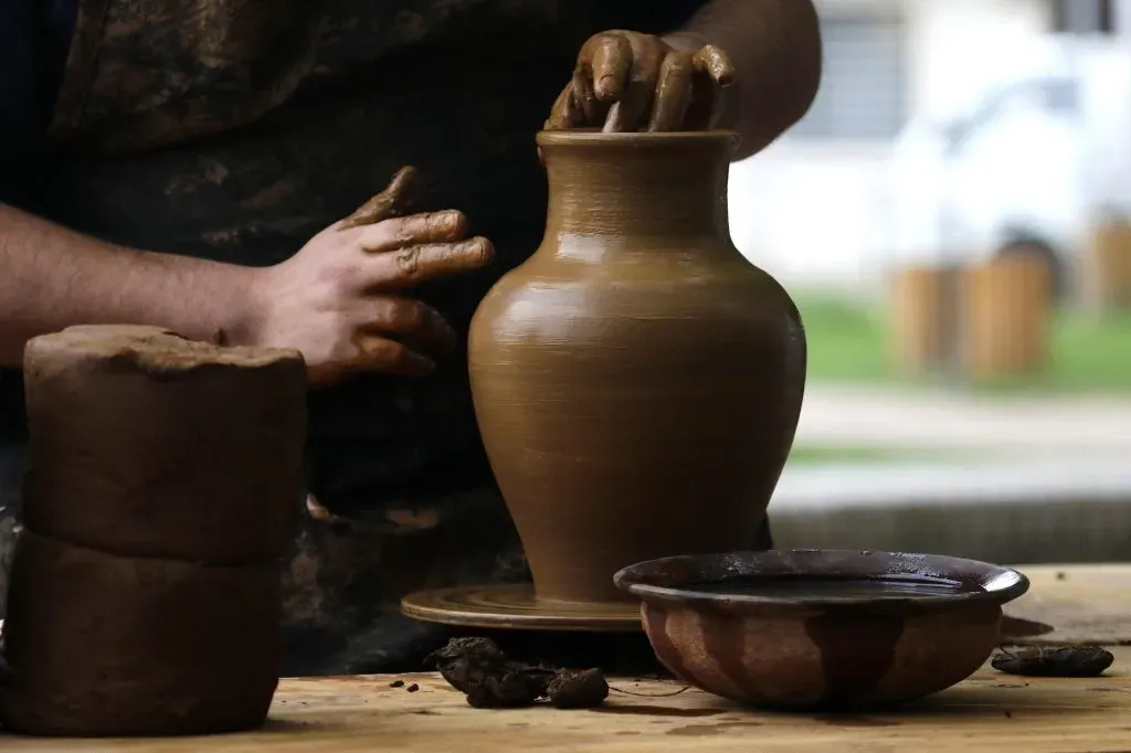 Artesano de Pomaire trabajando en un recipiente de greda