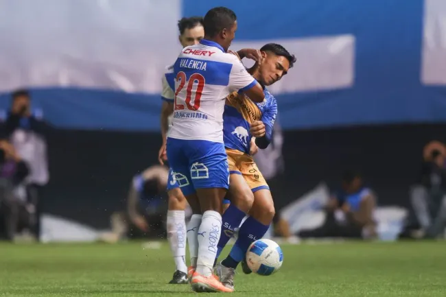 Jhojan Valencia y un roce con Joan Cruz en un duelo entre la UC y Everton. (Felipe Zanca/Photosport).