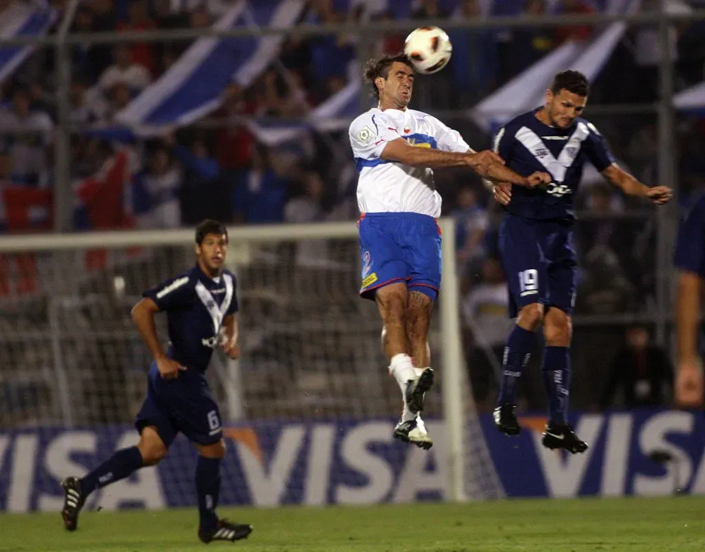 Fernando Ortiz ante Lucas Pratto en un duelo entre la UC y Vélez Sarsfield. (FERNANDO NAHUEL/PHOTOSPORT).