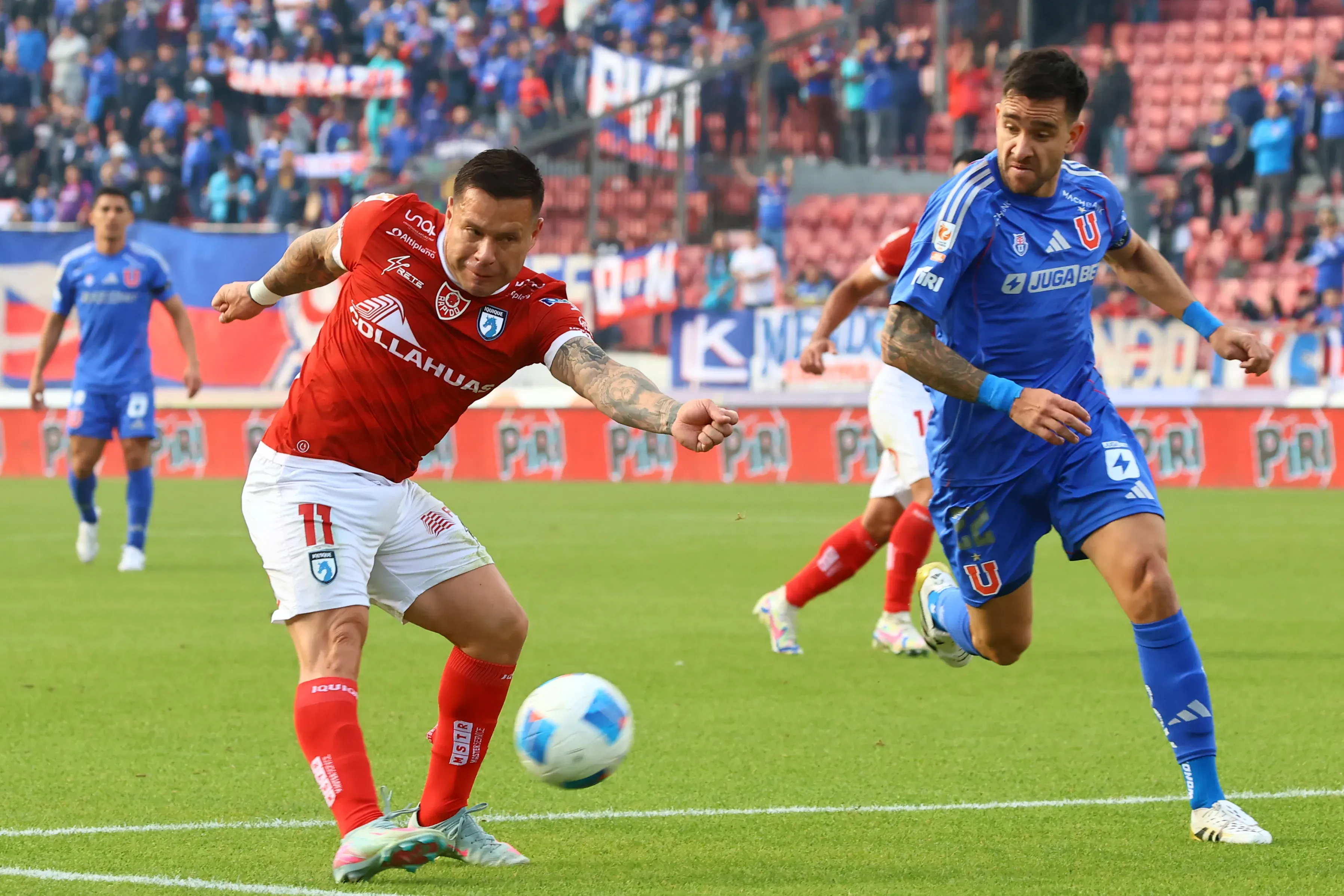 Álvaro Ramos ante Matías Zaldivia en la visita de Iquique a la U, que debe viajar al norte en la última fecha. (Jonnathan Oyarzun/Photosport).