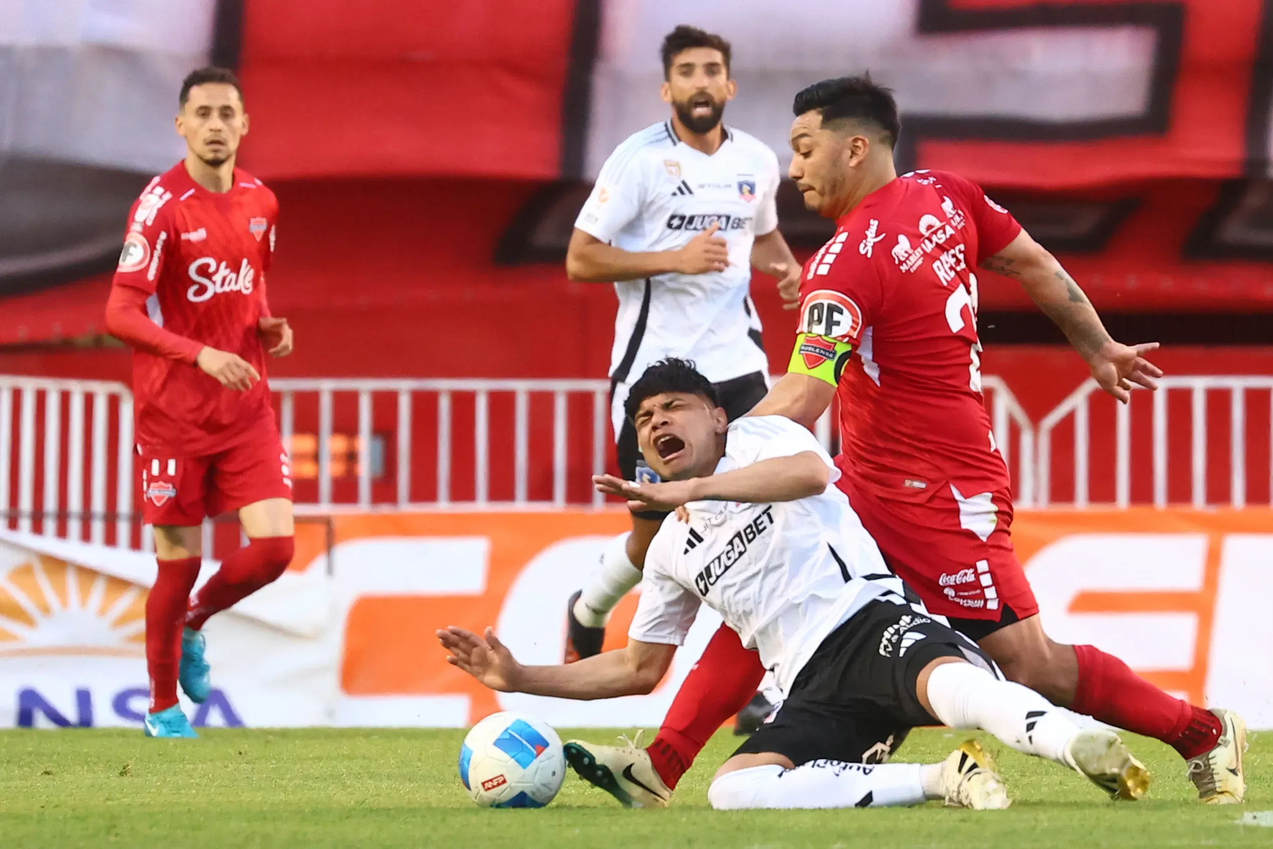 Claudio Aquino lucha un balón ante Lorenzo Reyes de Ñublense. (Eduardo Fortes/Photosport).