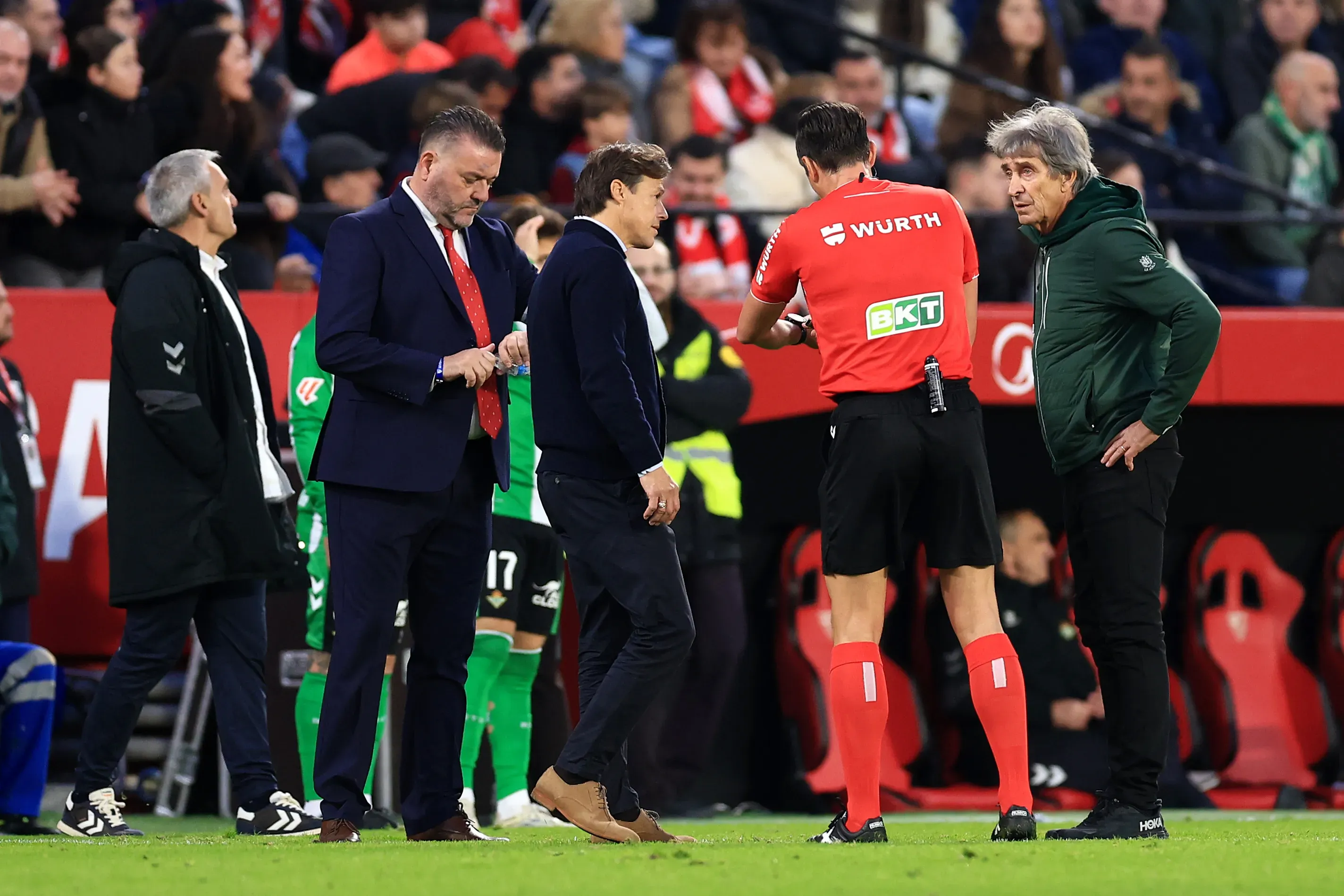 José Luis Munuera Montero conversando con Almeyda y Pellegrini durante los incidentes del clásico andaluz. (Photo by Fran Santiago/Getty Images)
