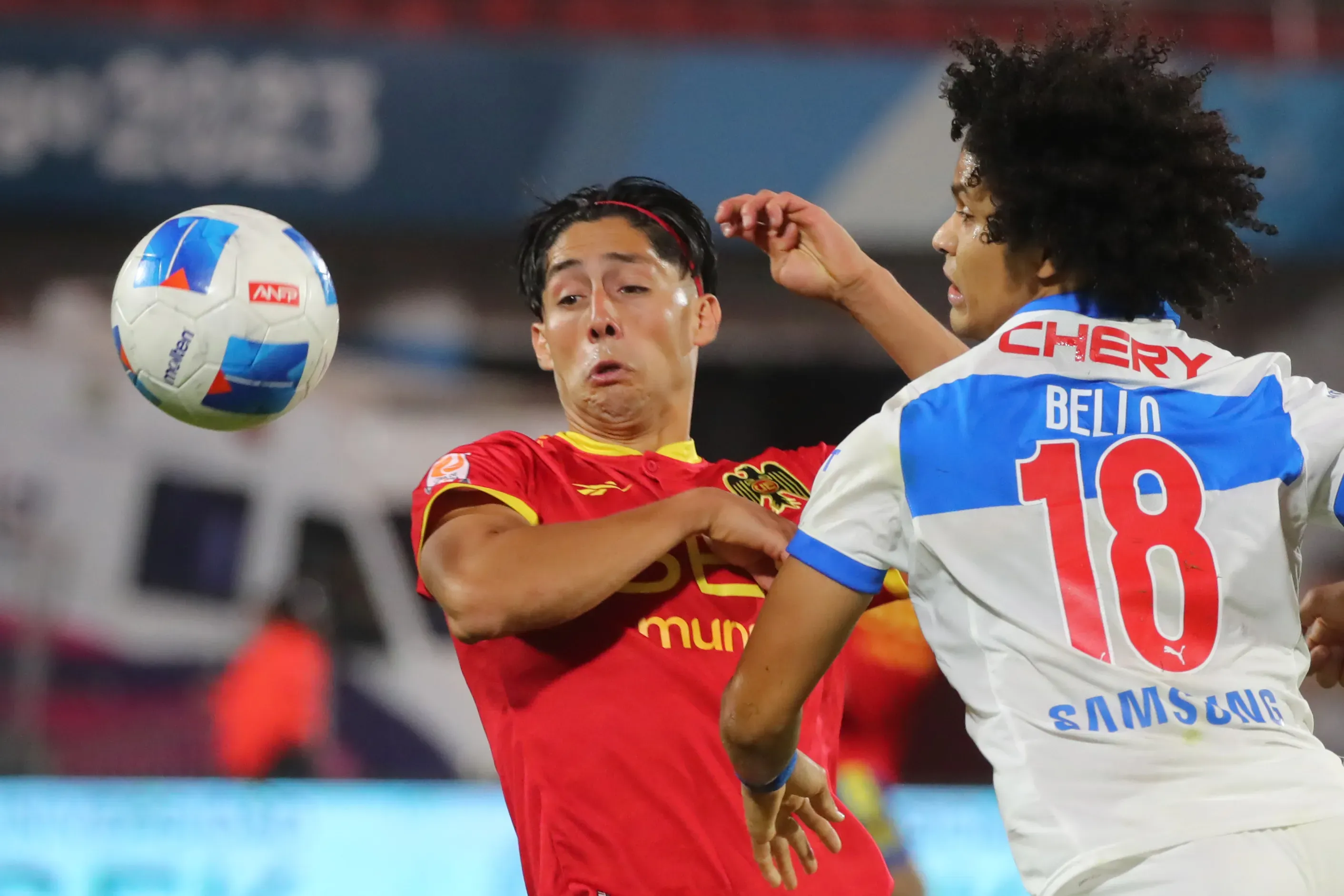 Simón Ramírez lucha un balón con el venezolano Eduard Bello en un duelo de UC y Unión Española. (Jonnathan Oyarzun/Photosport).