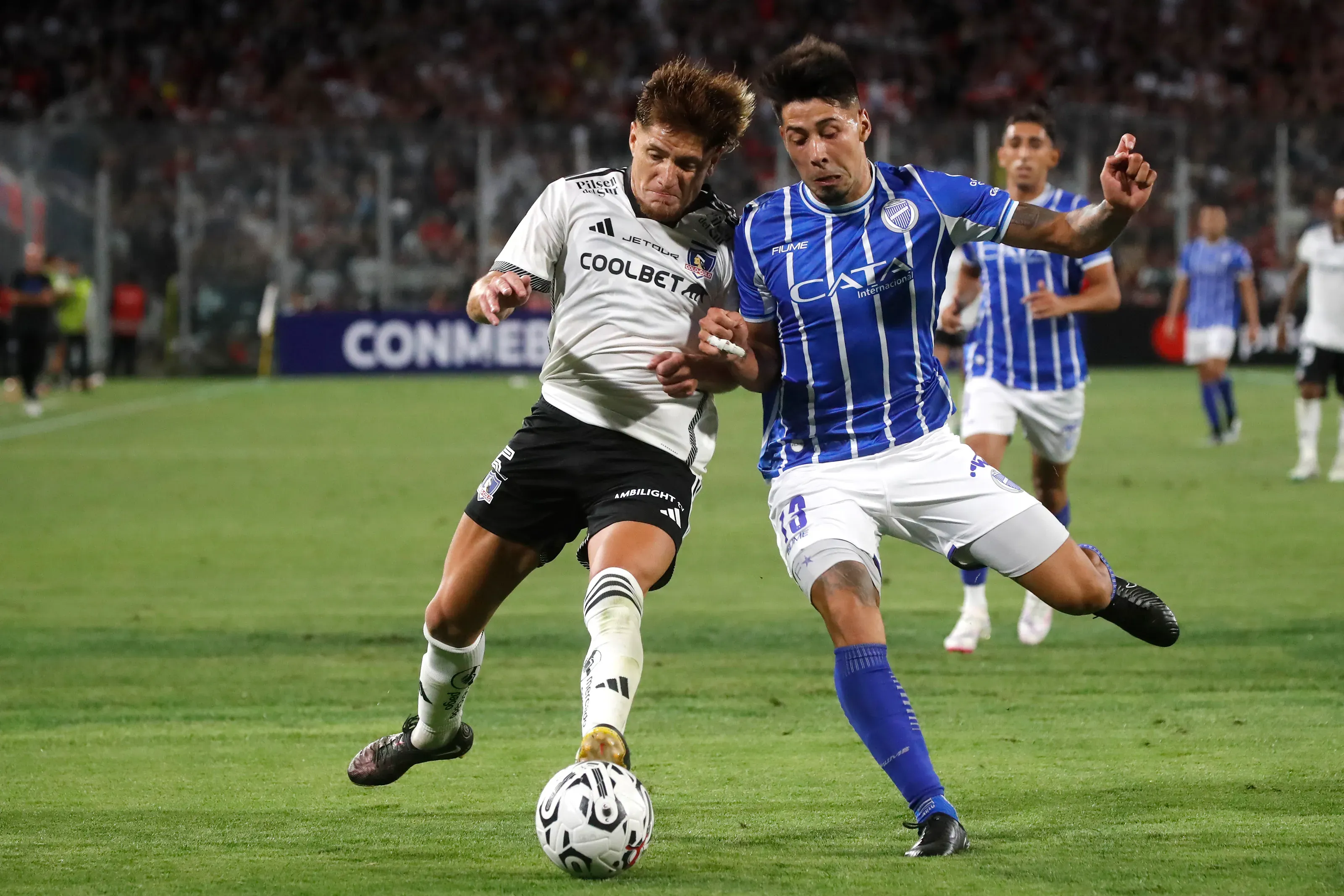 Nicolás Fernández en acción ante Leonardo Gil por la Copa Libertadores 2024, donde Colo Colo eliminó a Godoy Cruz. (Jonnathan Oyarzun/Photosport).
