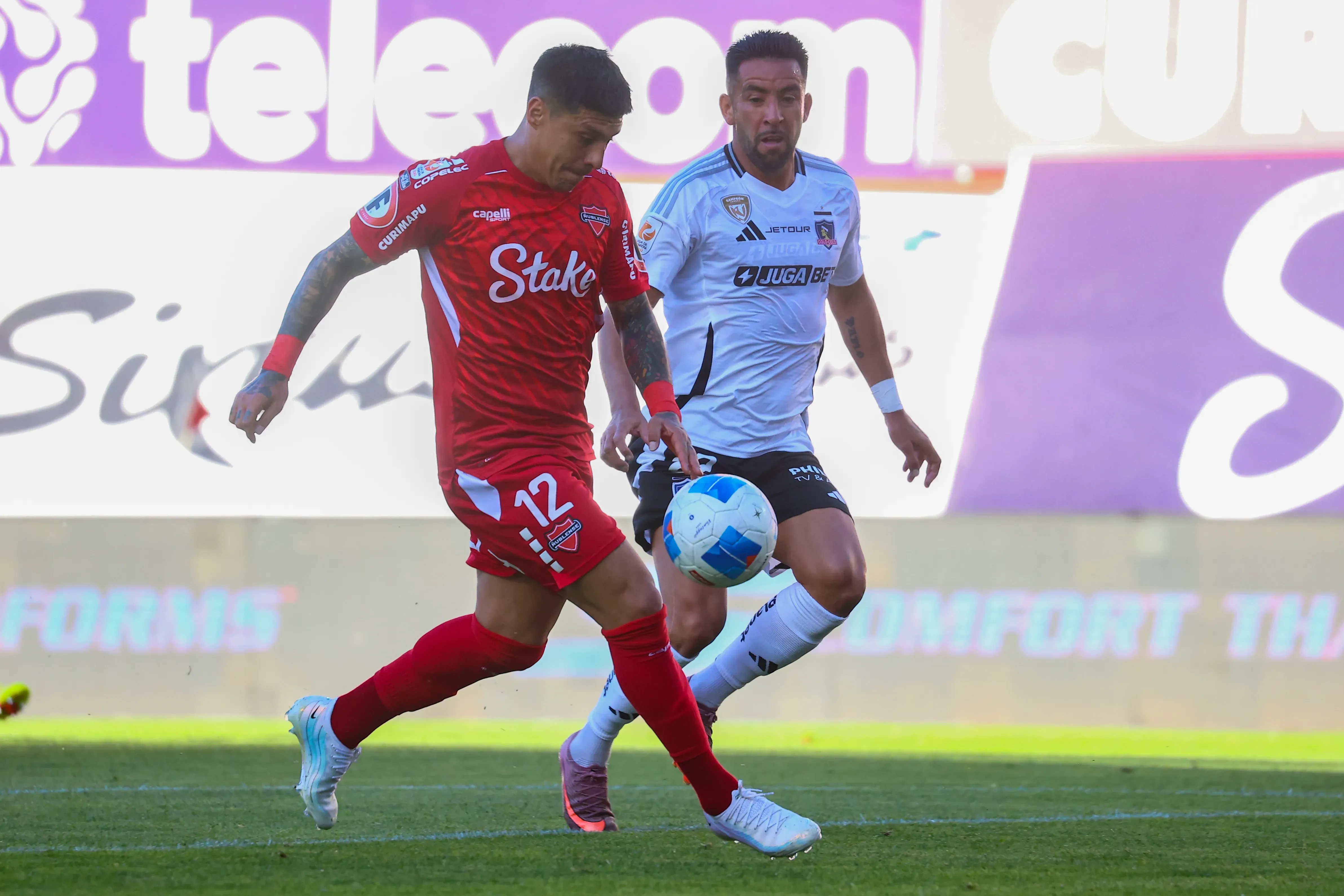 Patricio Rubio ante Mauricio Isla. Uno salió de Ñublense y el otro, se fue de Colo Colo. (Eduardo Fortes/Photosport).