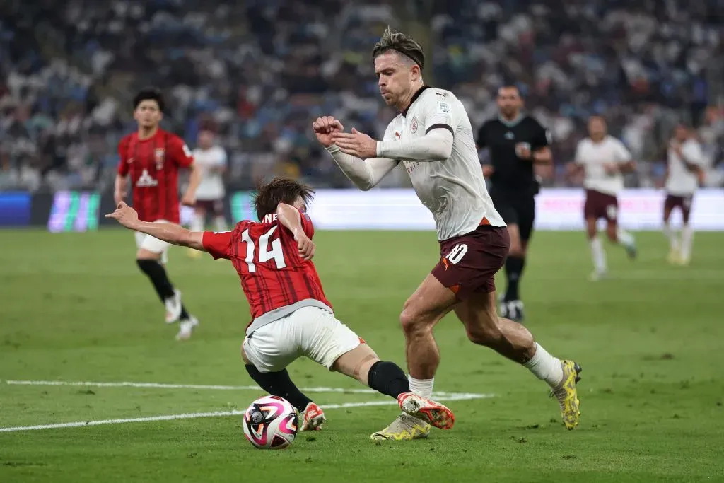 JEDDAH, SAUDI ARABIA – DECEMBER 19: Jack Grealish of Manchester City is challenged by Takahiro Sekine of Urawa Red during the FIFA Club World Cup Saudi Arabia 2023 Semi-Final match between Urawa Reds and Manchester City at King Abdullah Sports City on December 19, 2023 in Jeddah, Saudi Arabia. (Photo by Francois Nel/Getty Images)