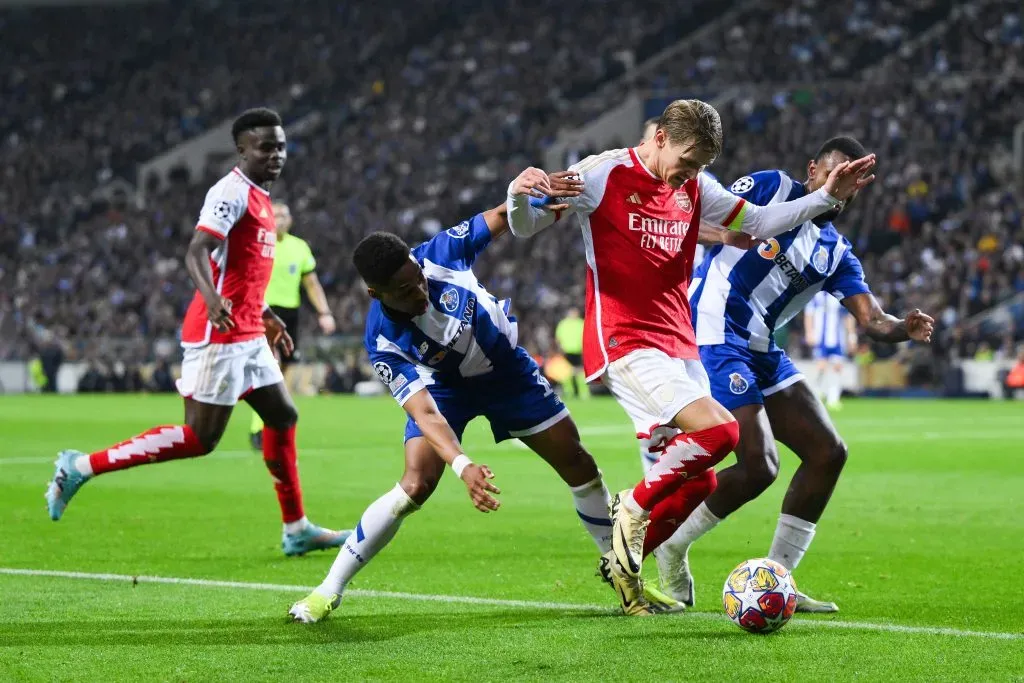 Odegaard tenta passar por Wendell e Otávio, no jogo de ida entre Arsenal e Porto, no Estádio do Dragão (Photo by David Ramos/Getty Images)