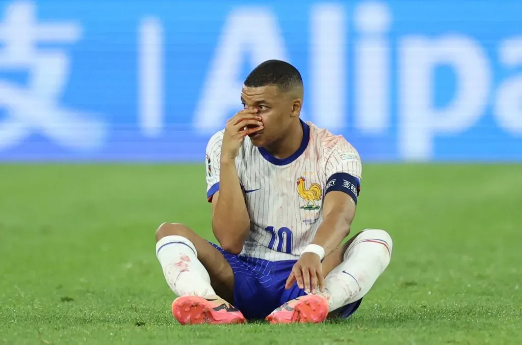 Mbappé no gramado após sofrer choque no nariz. (Photo by Kevin C. Cox/Getty Images)